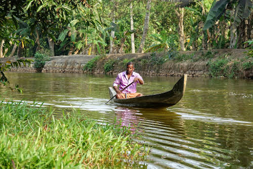 Inde. Voyage sur la route de la moto de Kerala. Pêcheur dans l’eau dormante Kumarakom
