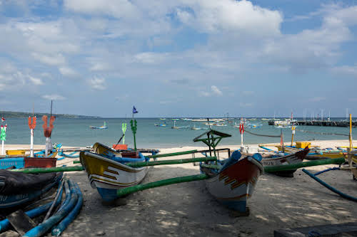 Indonésie. Cours de cuisine de Bali. Bateaux de pêcheurs par le marché de poissons de Jimbaran